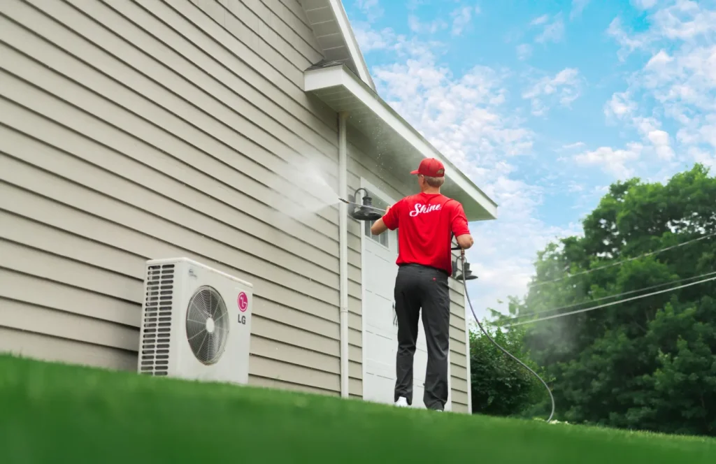 Shine technician pressure washing the exterior of a residential home.
