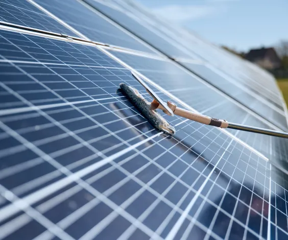 Technician cleaning solar panels with professional equipment