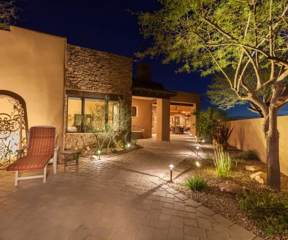 Residential outdoor lighting illuminating a home and landscaped walkway at night
