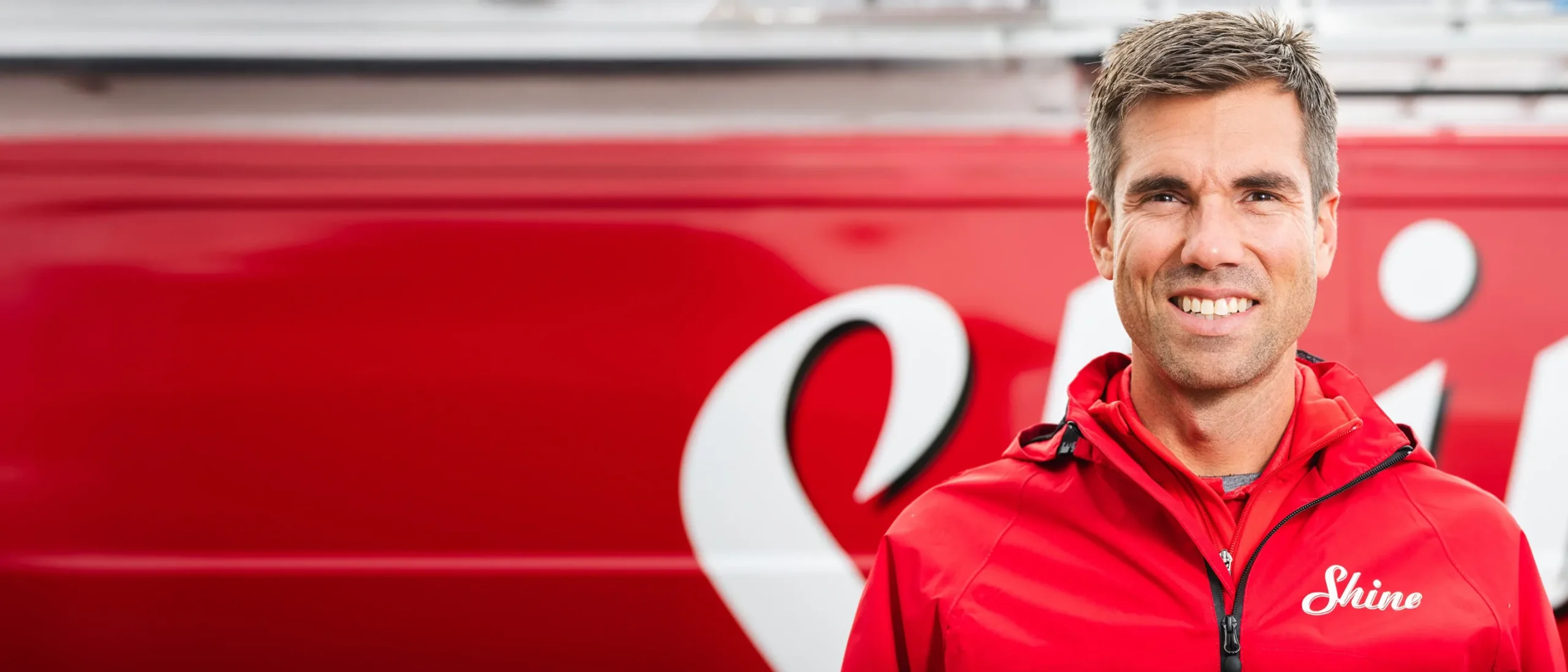 Shine franchise owner standing in front of a branded service vehicle.